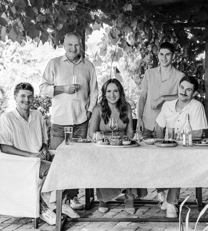 Skara family gathered around table out under the patio